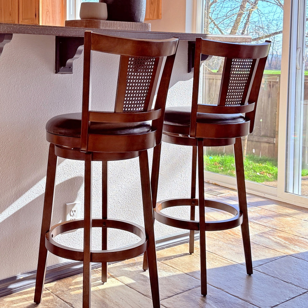 Two wooden bar stools with woven backrests in a kitchen setting.